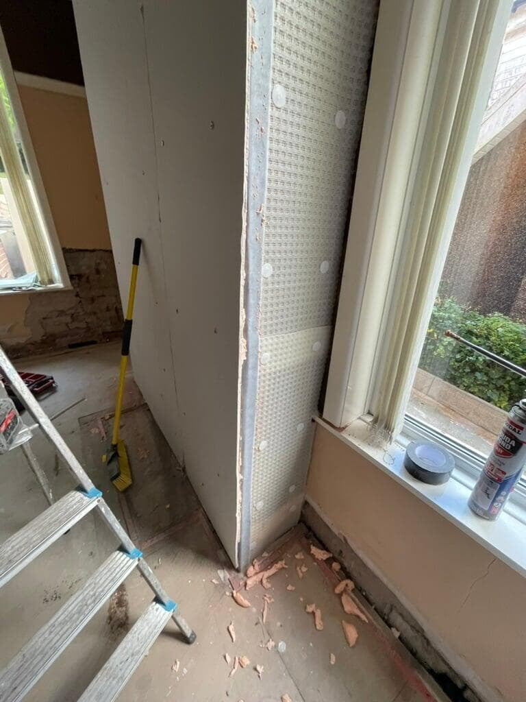 Damp-proof membrane and boarding fitted to a wall in Blackburn