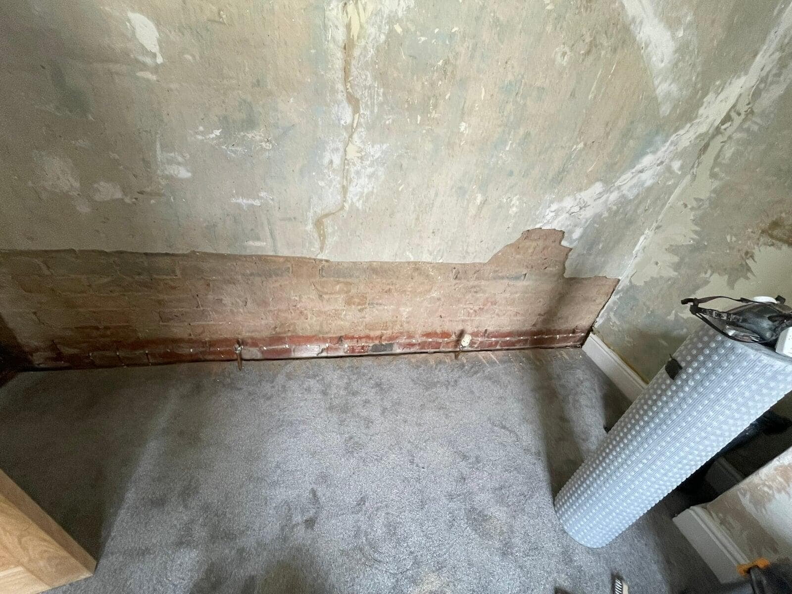 Stripped brick wall and copper pipework during damp proofing, Great Harwood
